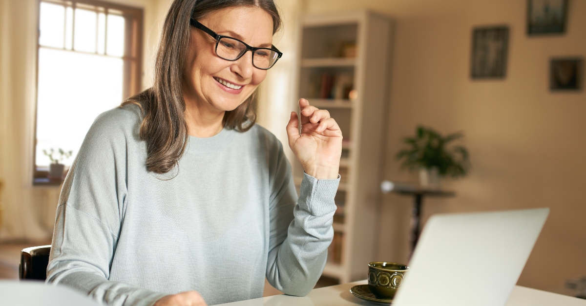 elderly woman using laptop for remote work