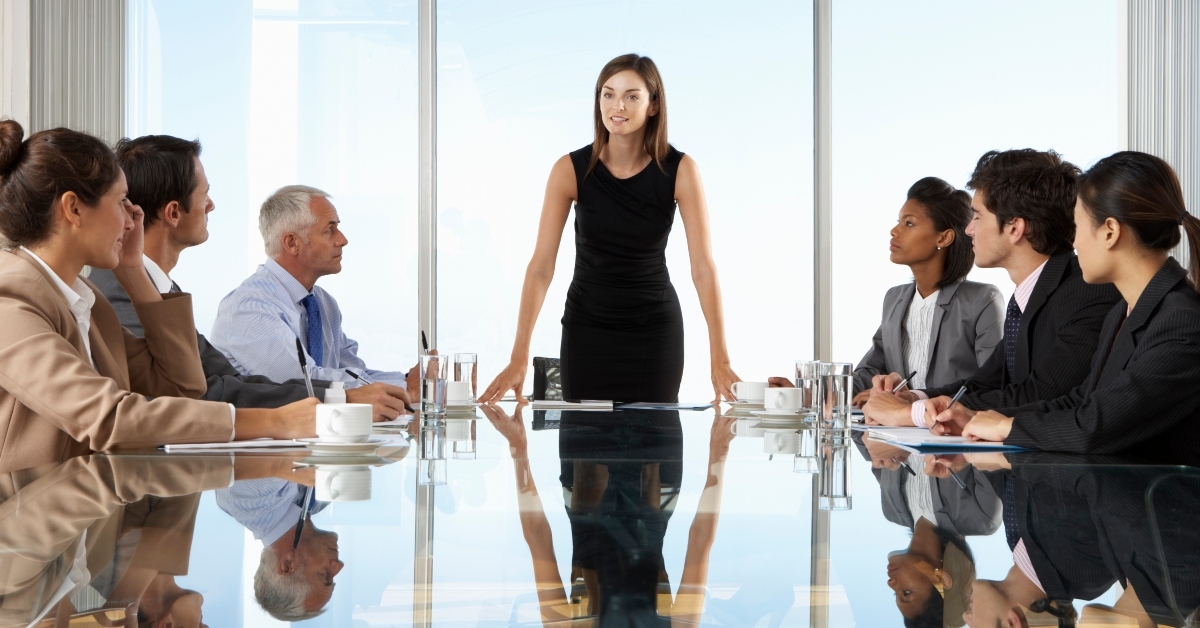 businesspeople having board meeting around glass table
