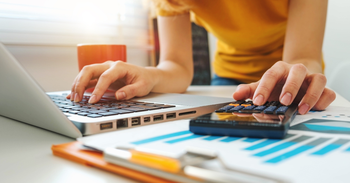 businesswoman working with finances using calculator and laptop