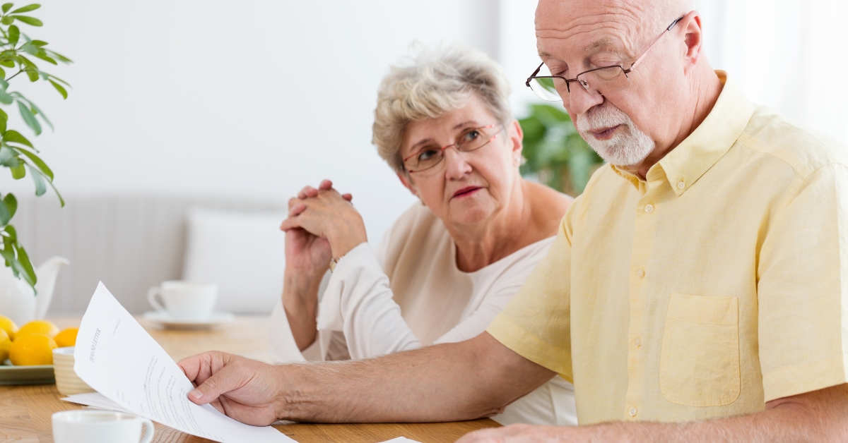 elderly couple calculating costs of household