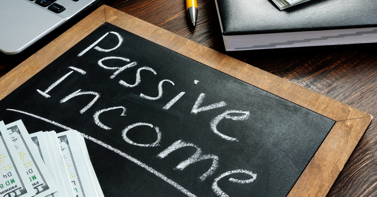 passive income inscription on the board and a bundle of bills