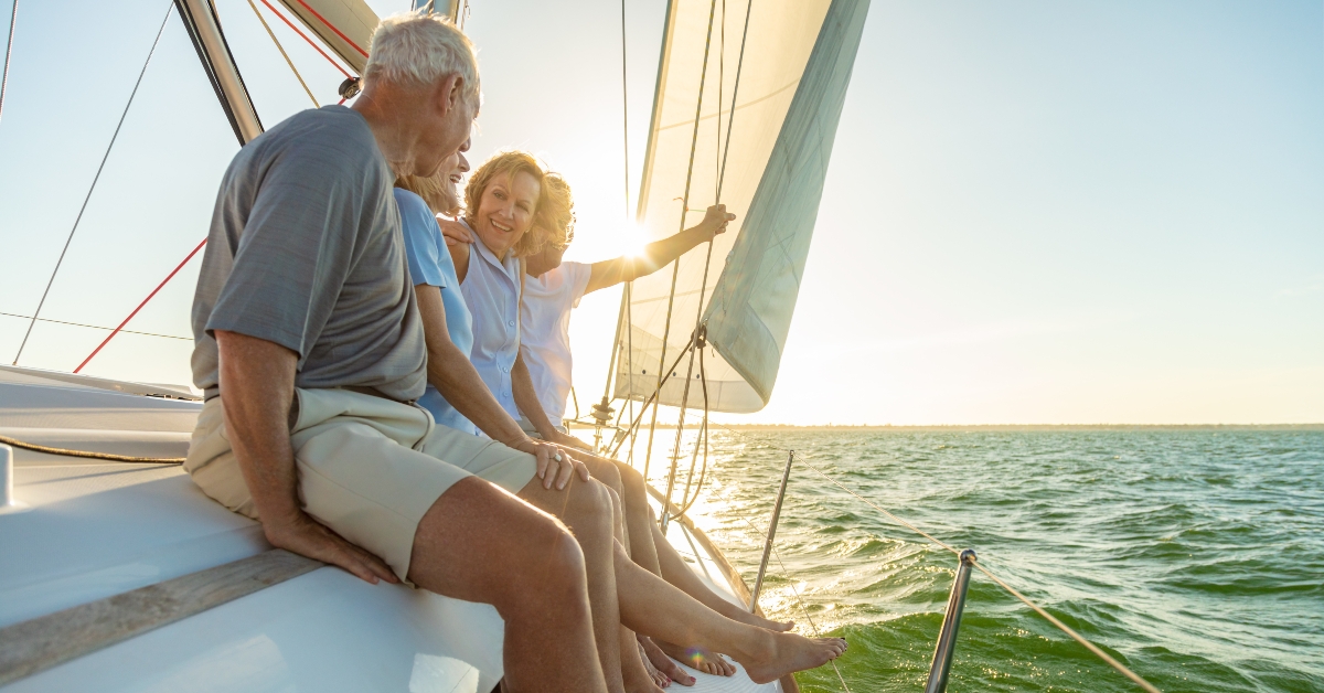 relaxed group of senior friends sailing luxury yacht