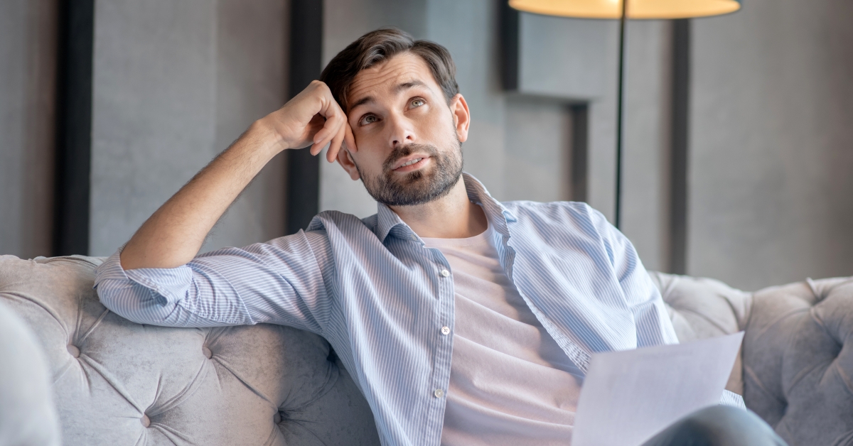 sad man sitting with a document in his hand