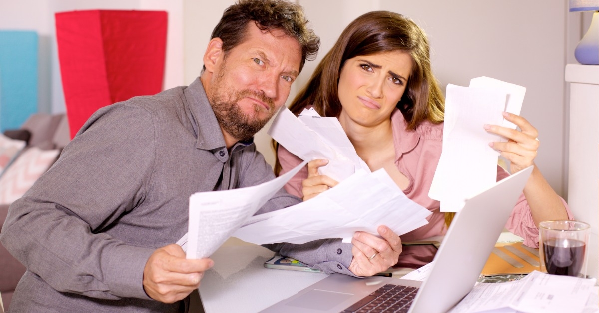 unhappy couple holding documents in hands