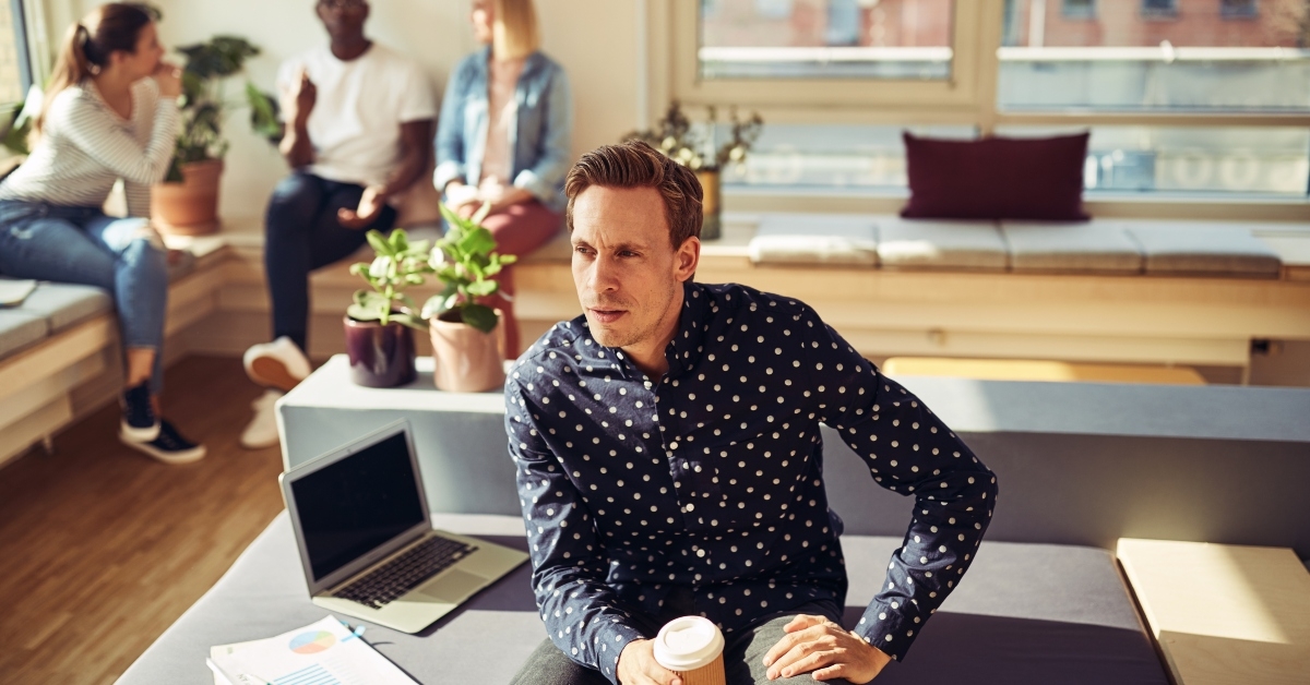 focused manager sitting with a coffee at his office desk