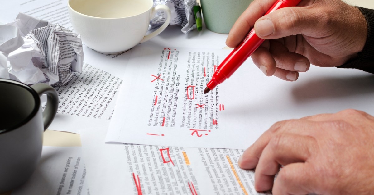 man under lining documents using red marker