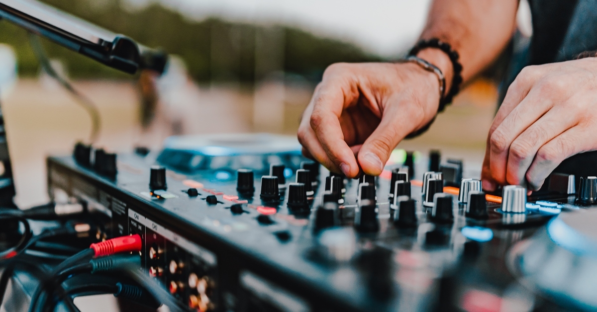 dj hands creating and regulating music on dj console mixer 