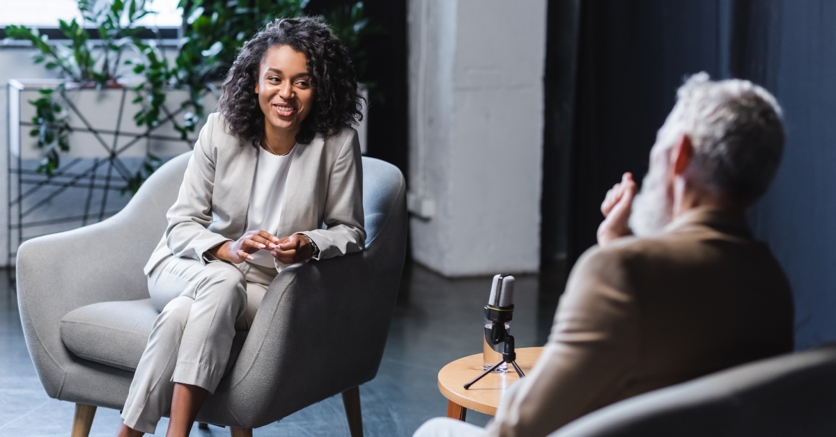 journalist gesturing while talking with businessman