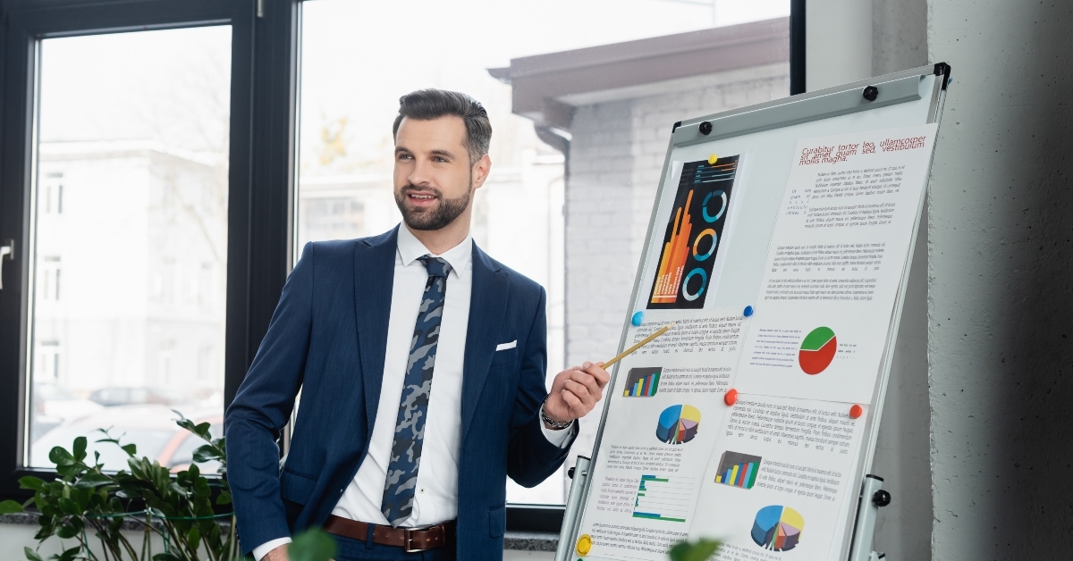 positive economist pointing at analytics on flipchart