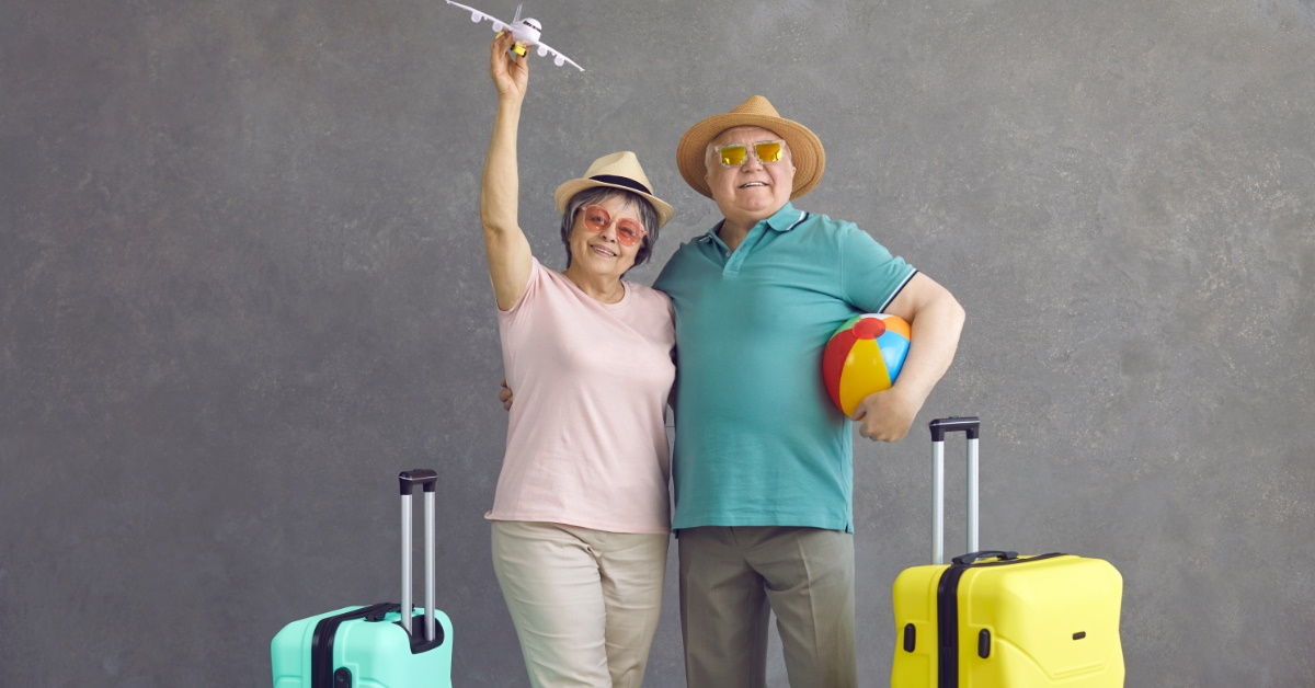 senior couple ready for travelling standing with suitcases