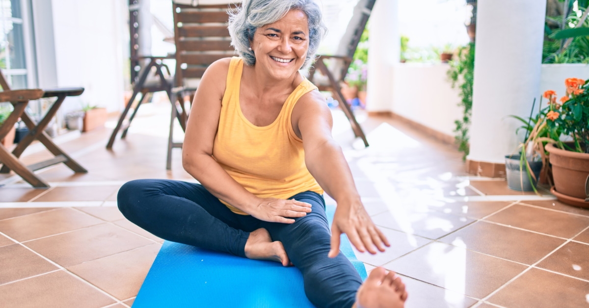 happy senior woman doing work out on yoga mat 