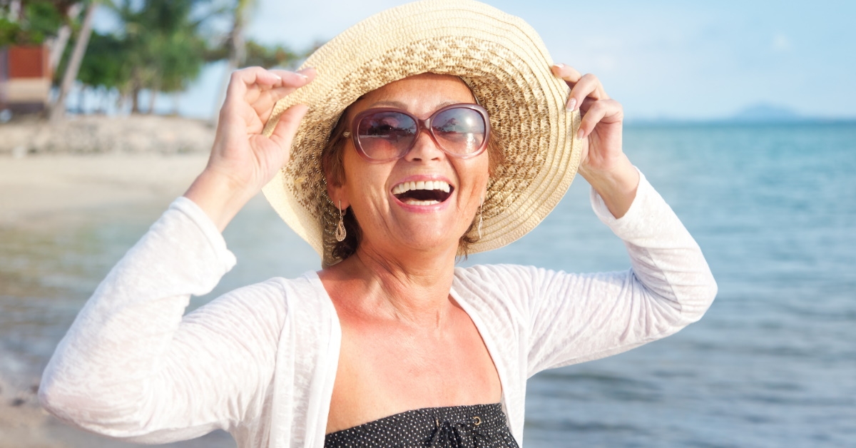 woman wearing beach hat enjoying time at beach