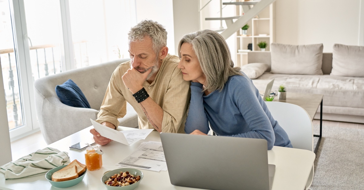 senior couple sitting on table reviewing documents
