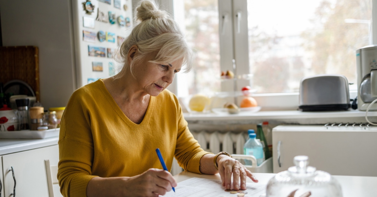 senior woman writing something on paper