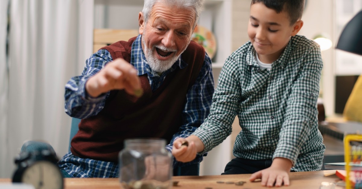 grandpa and grandson putting pennies in mason jar 