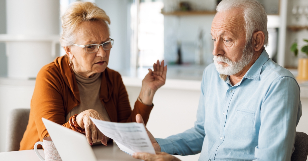 senior couple sitting at home and checking their home finances