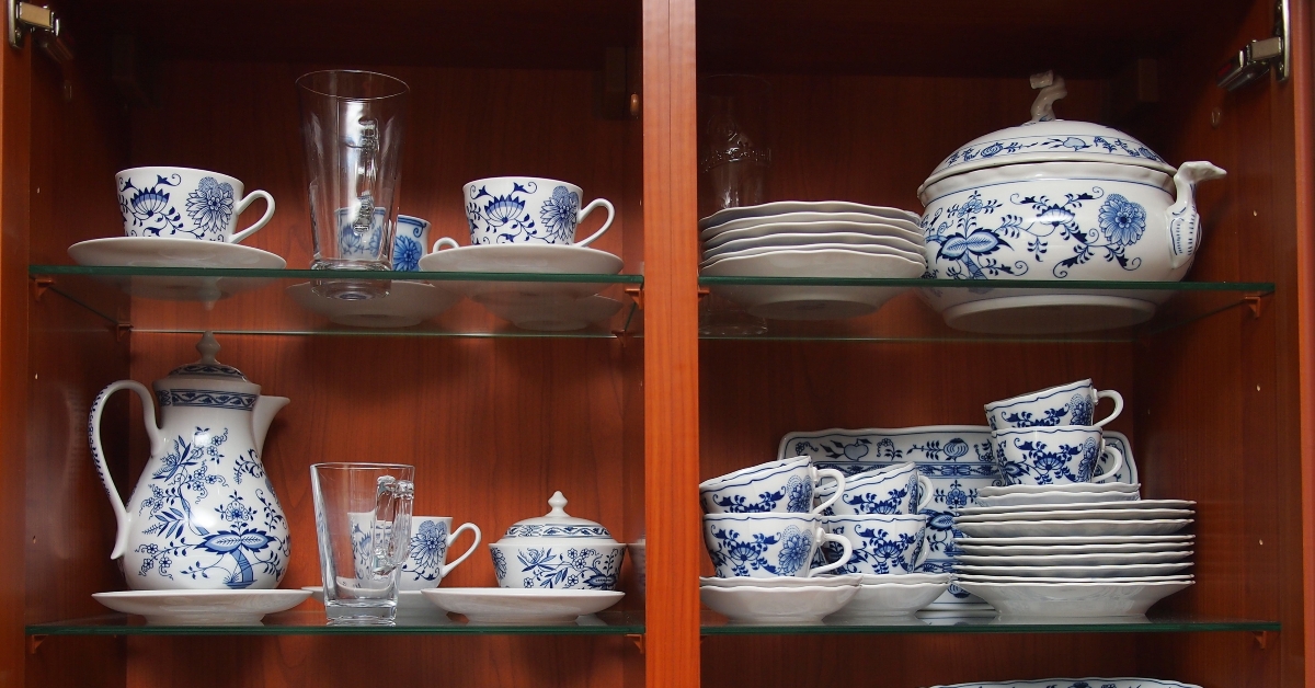 mugs cups and plates in wooden cabinet