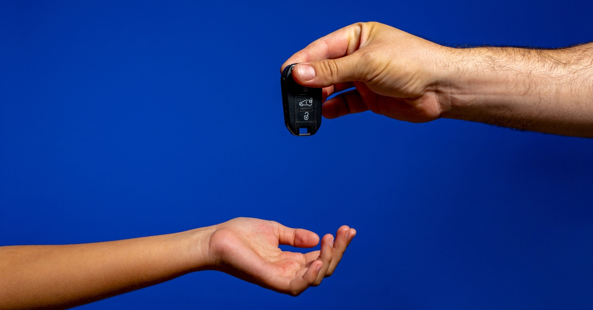 senior man hand over car key to his daugther