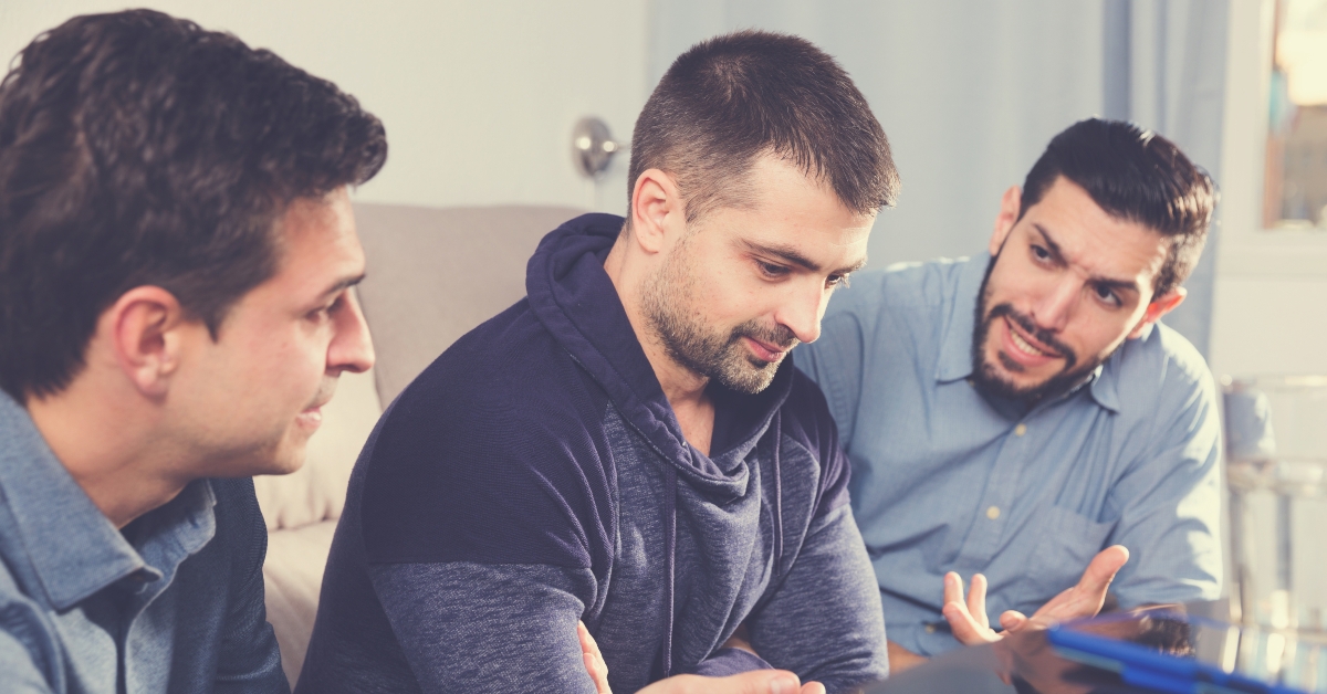 two troubled men talking with friend