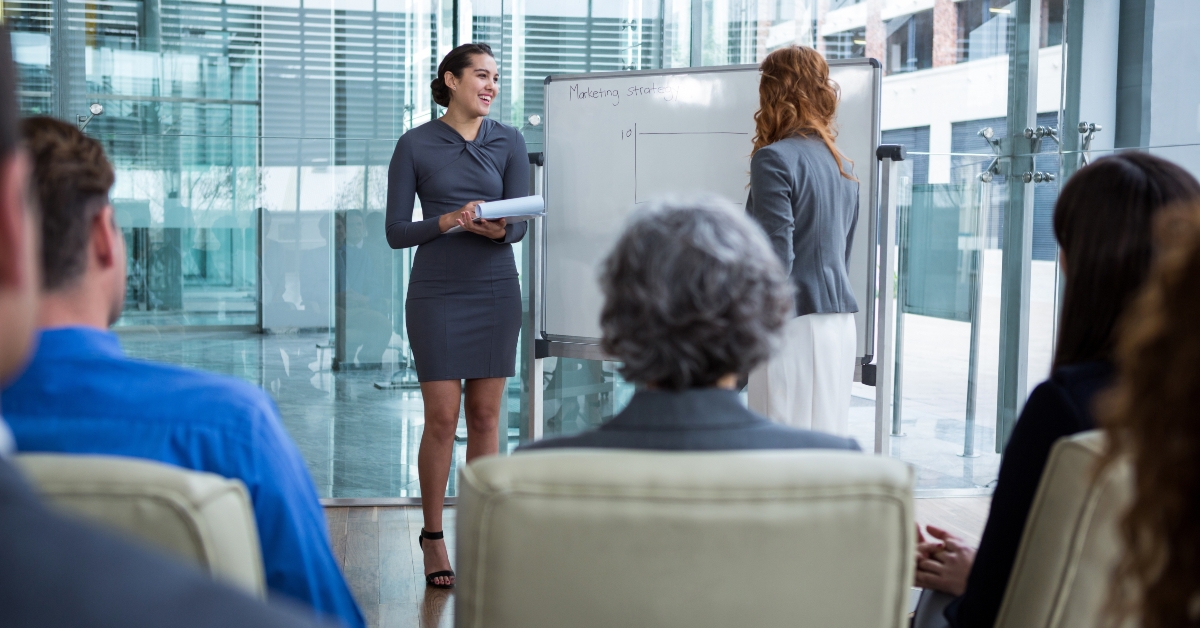 businesswomen discussing on white board with coworkers