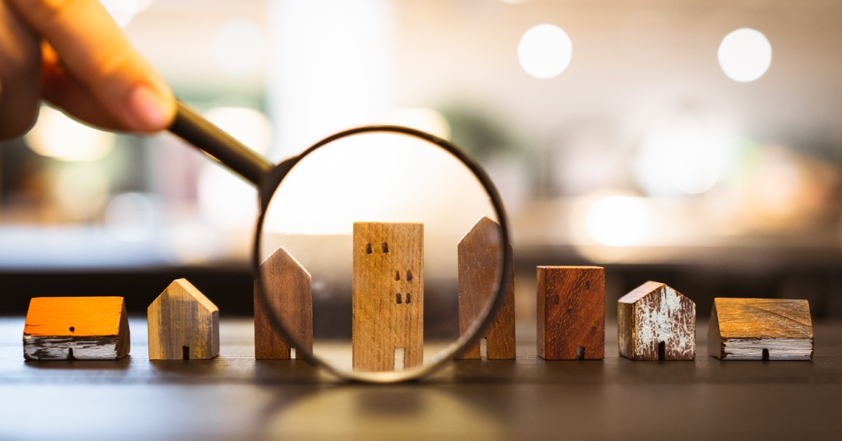 A magnifying glass inspecting small house models
