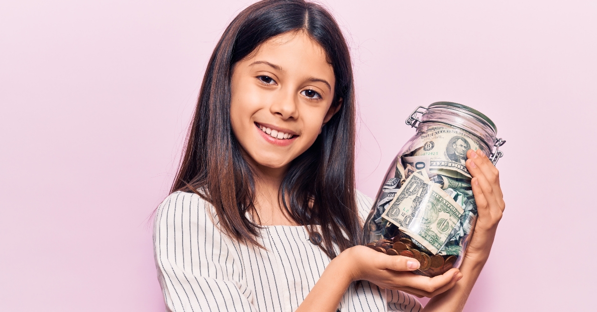 girl holding jar with savings looking positive