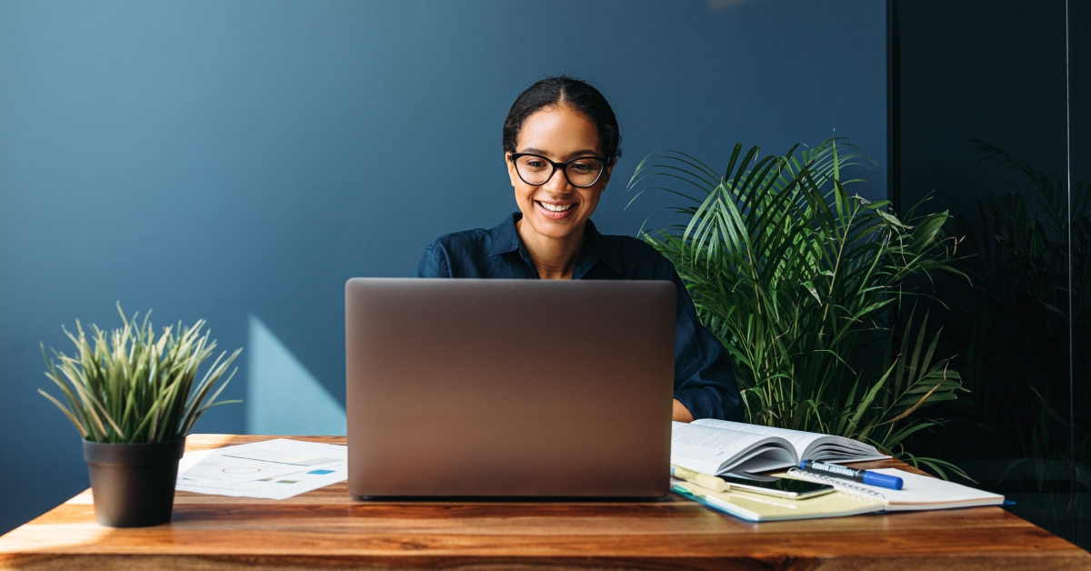 smiling entrepreneur sitting at home working on laptop