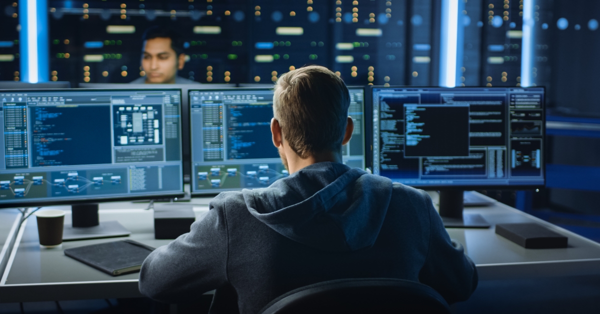IT specialist works on personal computer with screens