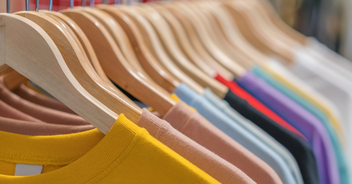 colorful t shirts on hangers for sale at store
