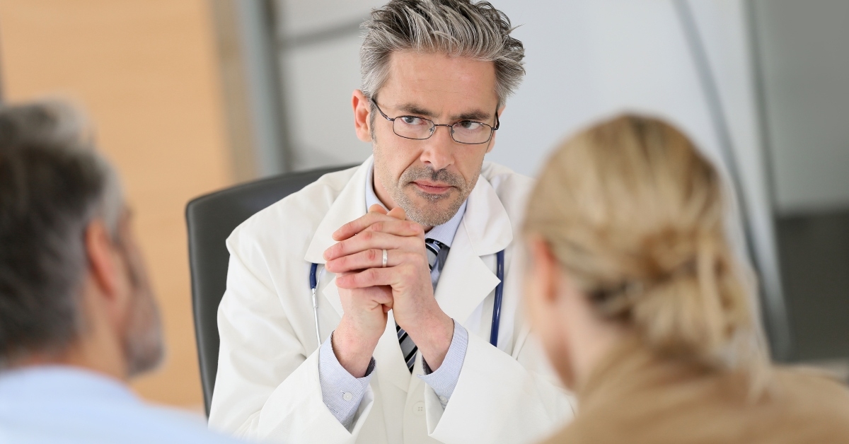 doctor meeting couple in hospital office