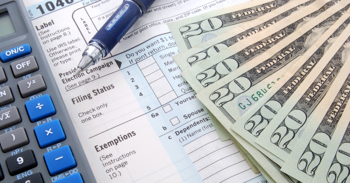 dollar bills with calculator pen and 1040 form