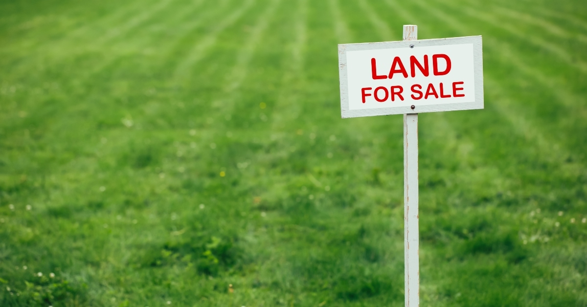 land for sale sign against trimmed lawn