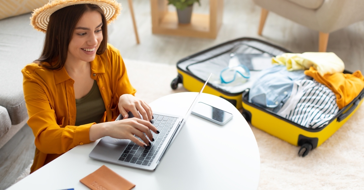 young woman planning vacation travel with laptop