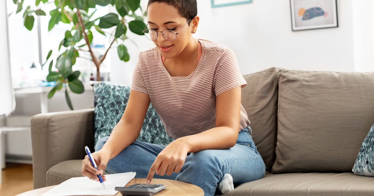 woman in glasses with papers and calculator at home