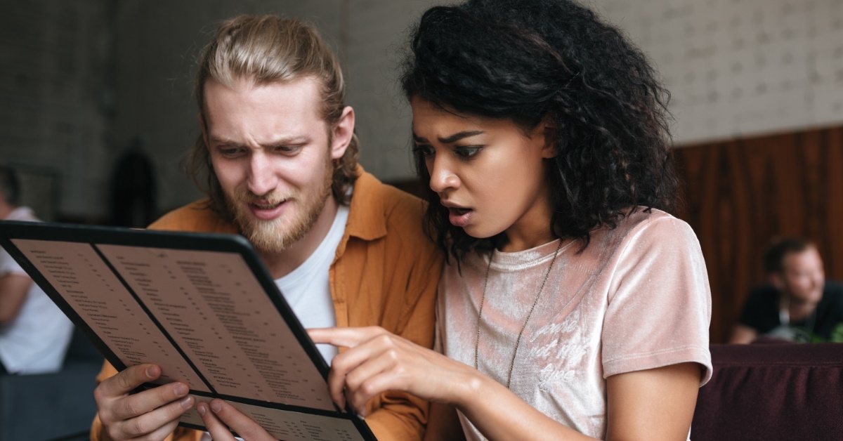 young couple sitting in restaurant checking out menu