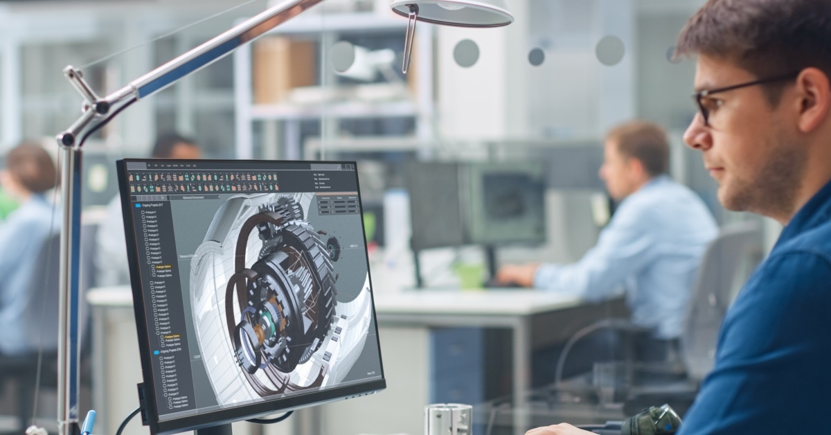 mature engineer wearing glasses is using CAD while sitting in a chair at the office