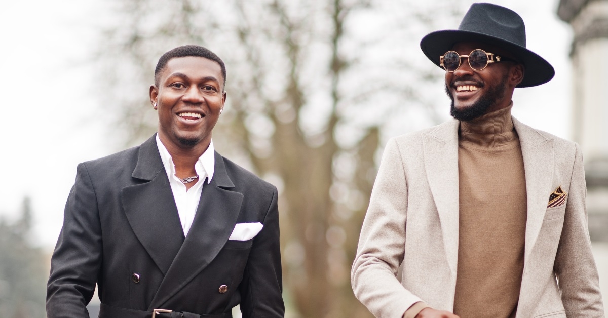 two fashionable happy african american men walking in street