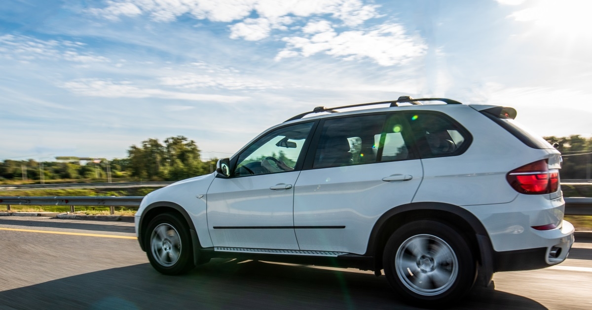 white car running at full speed on the highway during the day