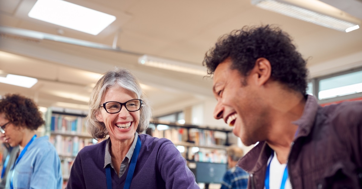 group of adults sitting in library laughing