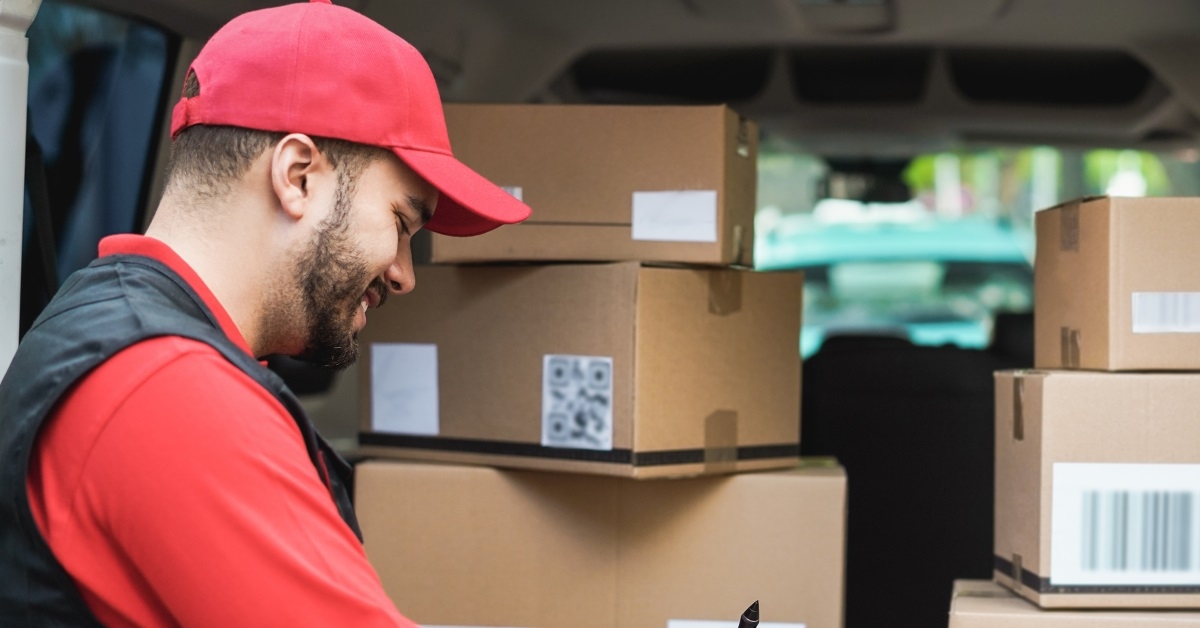 delivery man with van full of boxes signing on tablet