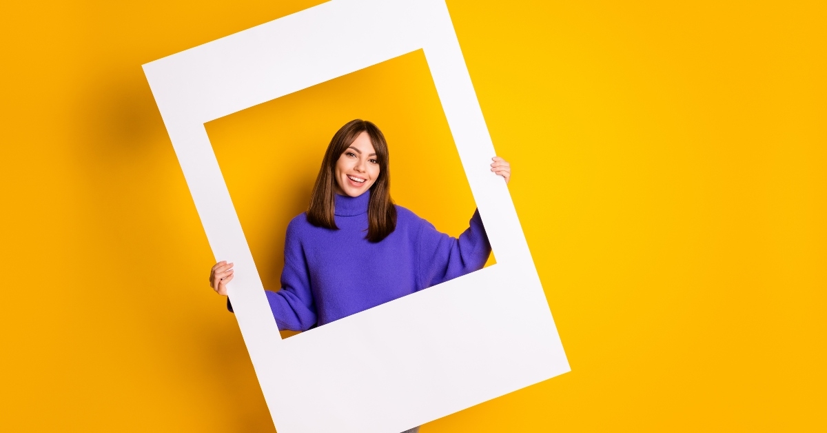 attractive cheerful girl holding in hands big paper frame