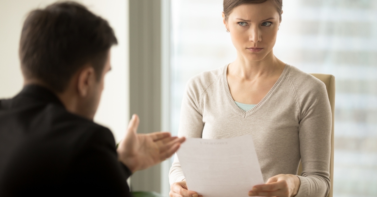 businesswoman with skeptical facial expression holding contract