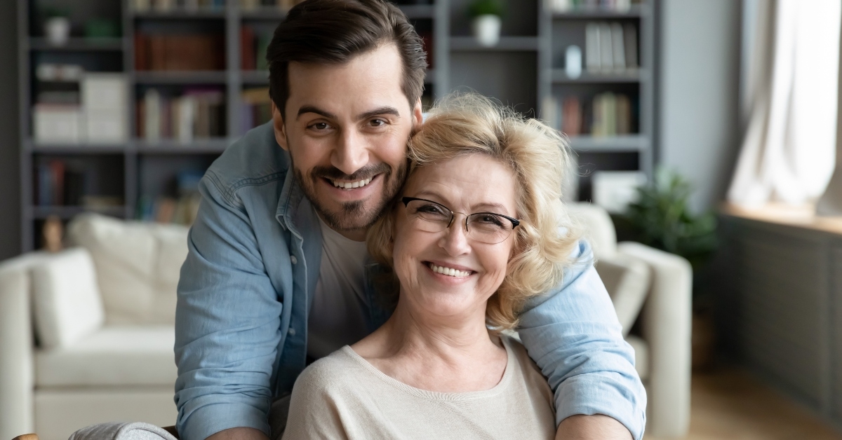 grateful adult son hugging senior mother