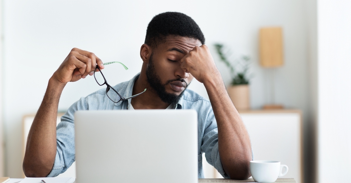 male employee having headache after working on laptop