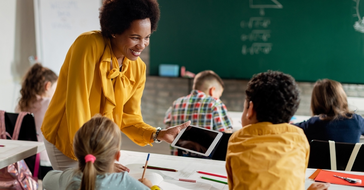 teacher and elementary students using digital tablet in the classroom