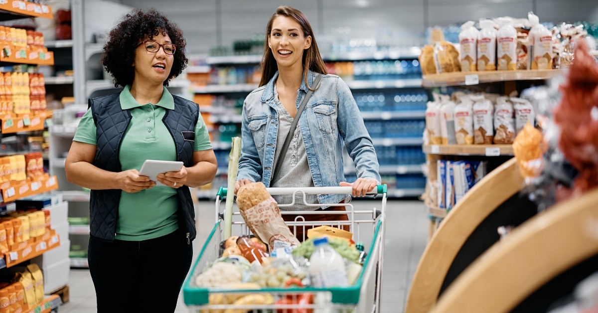 woman talks to supermarket worker adobe