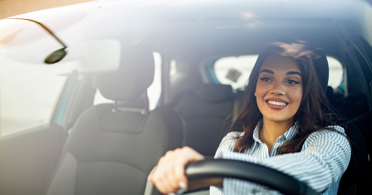 woman driving her new car at sunset