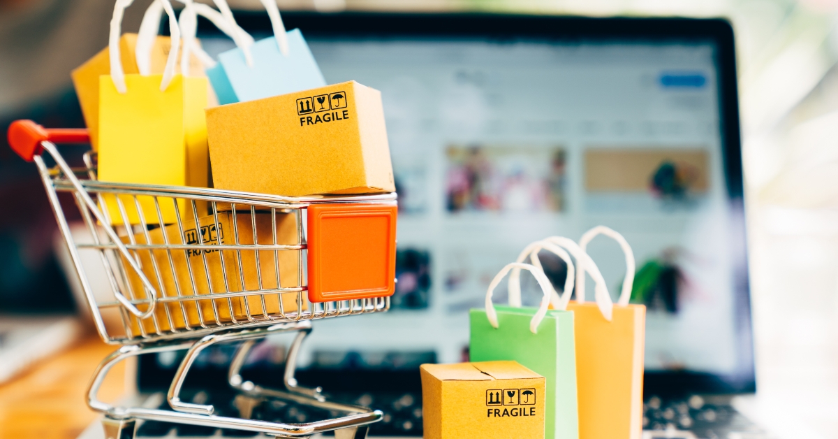 package boxes and shopping bag in cart with laptop