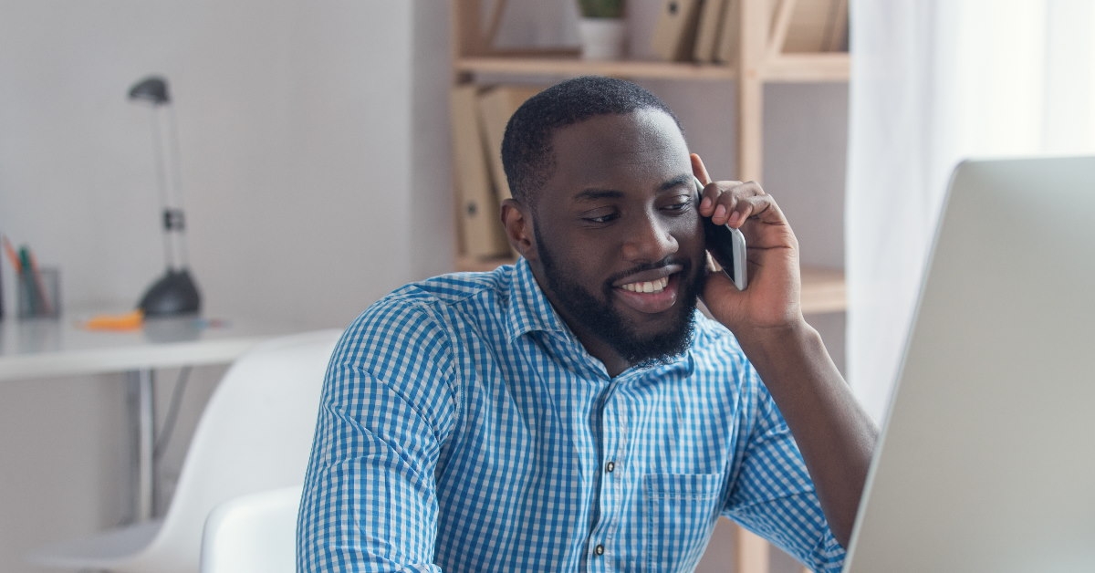 african american man at workplace talking on cellphone 