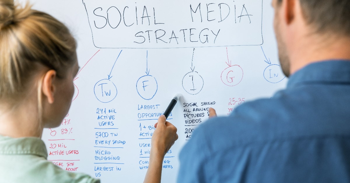 colleagues at a workplace discussing social media strategies on whiteboard